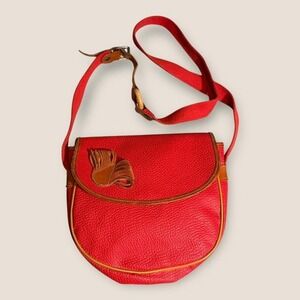 Red leather crossbody bag with a unique‎ design,